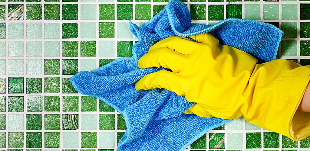 person doing housework wearing yellow rubber gloves