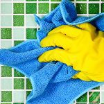 person doing housework wearing yellow rubber gloves