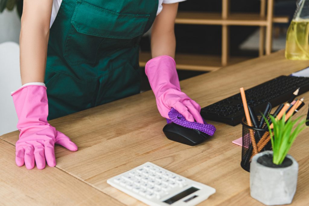 Cleaner cleaning commercial office desk space