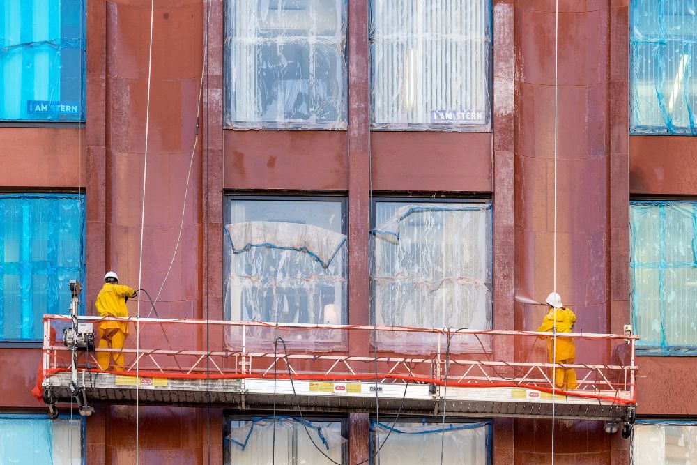 Jani king two men cleaning windows of large building