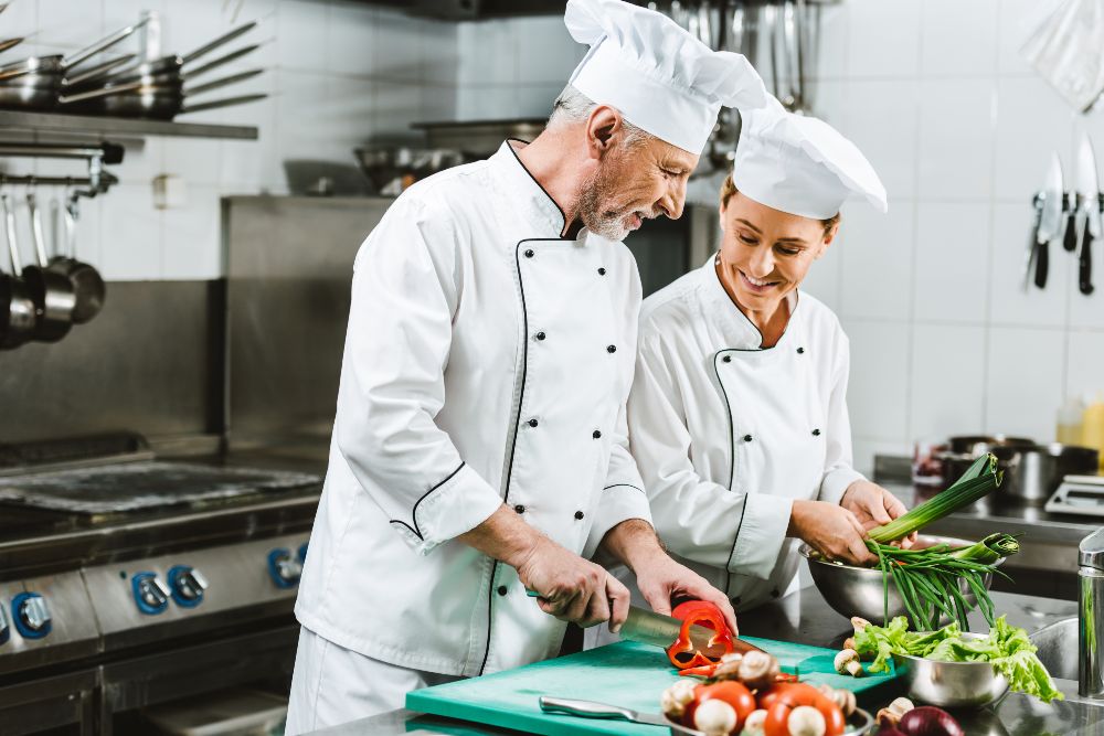 Jani king smiling female and male chefs in uniforms and hats