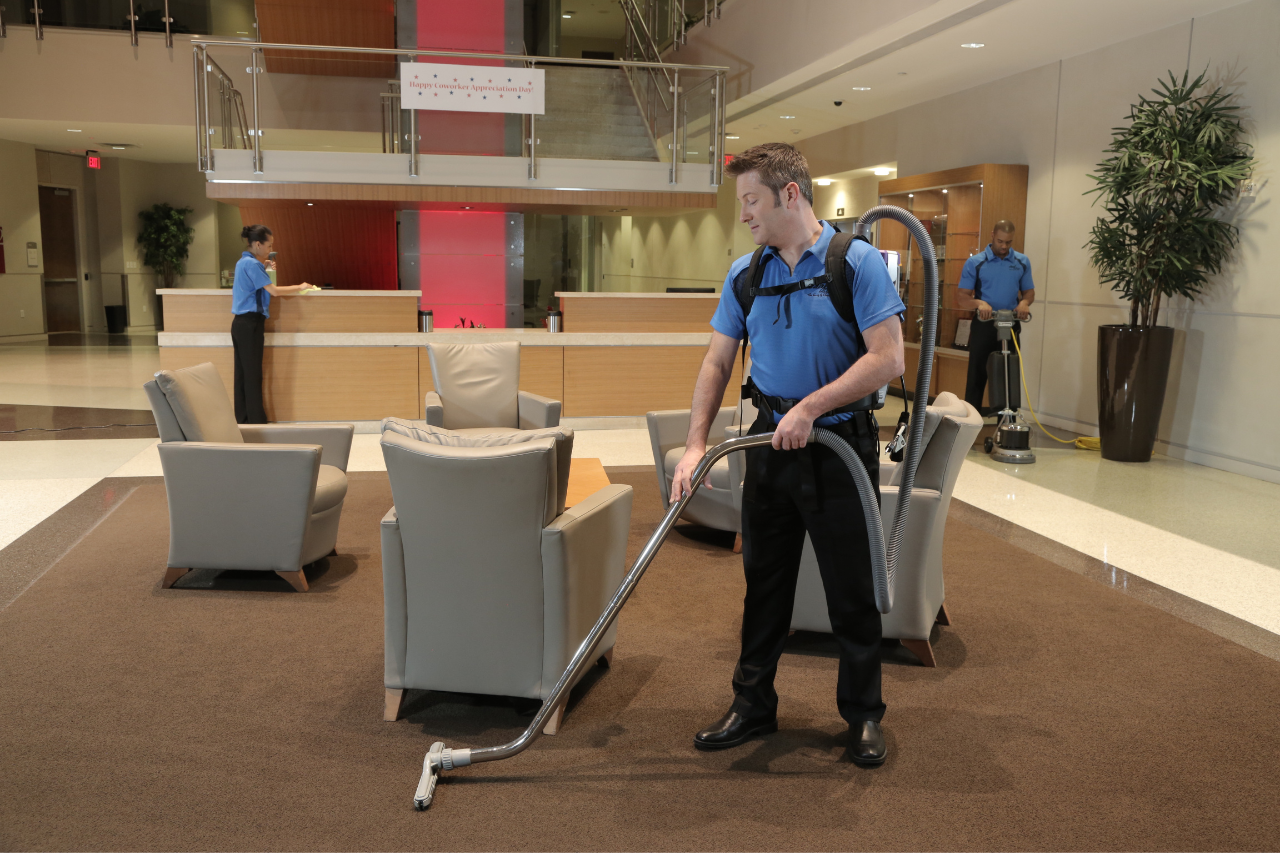 Man cleaning office floor with hoover